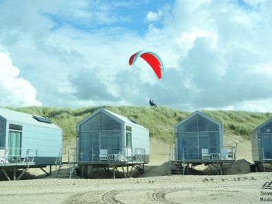 Vlieger boven strandhuisjes
